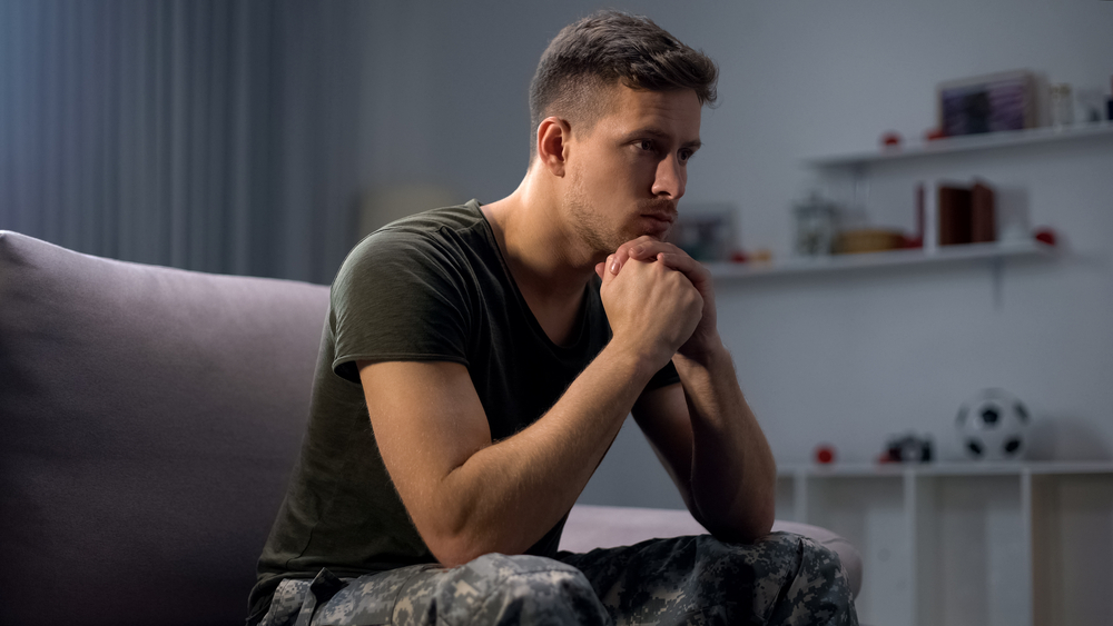 A man in uniform who’s experiencing Post Traumatic Stress Disorder symptoms