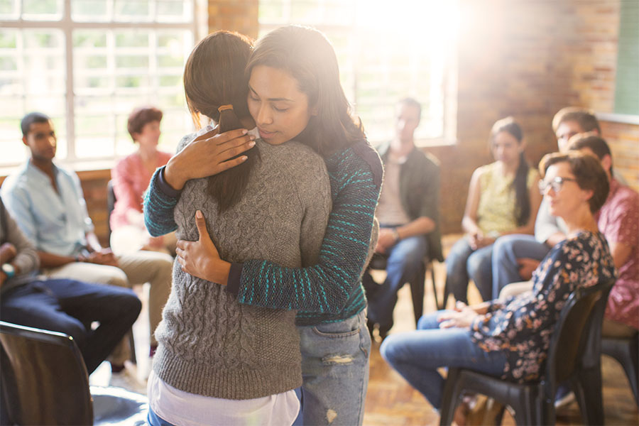 Counselor consoling young lady after sharing during the group therapy as part of the substance abuse treatment