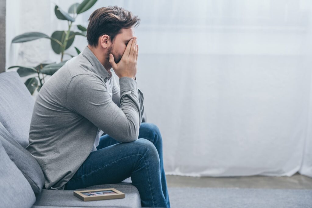 a man holding his head in his hands, struggling to accept his mental illness of anxiety and depression, hoping to find treatment options to relieve symptoms