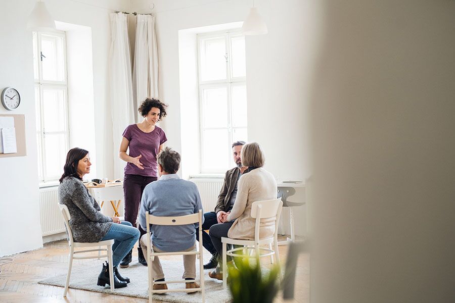 women talking to group of people during alcohol rehab treatment in Florida