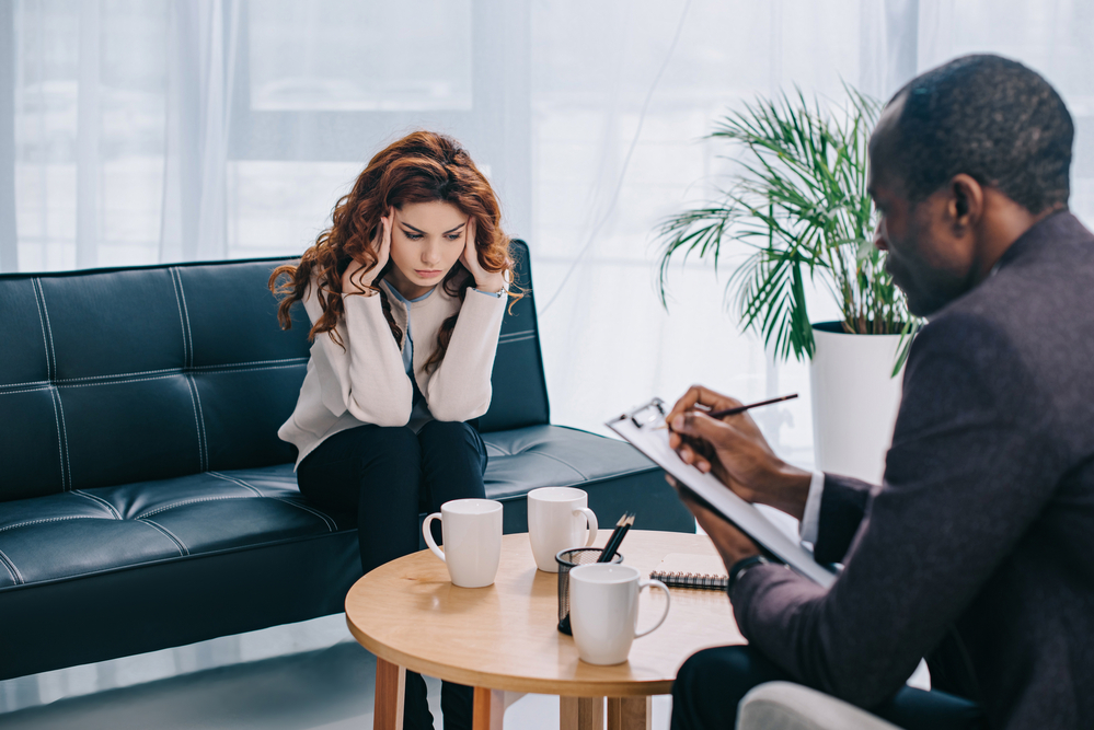 patient discussing her addiction problem with therapist at a rehab that accepts optum va ccn insurance