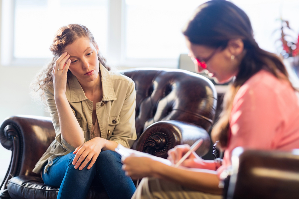 young woman speaking to counselor about her compsych mental health rehab coverage