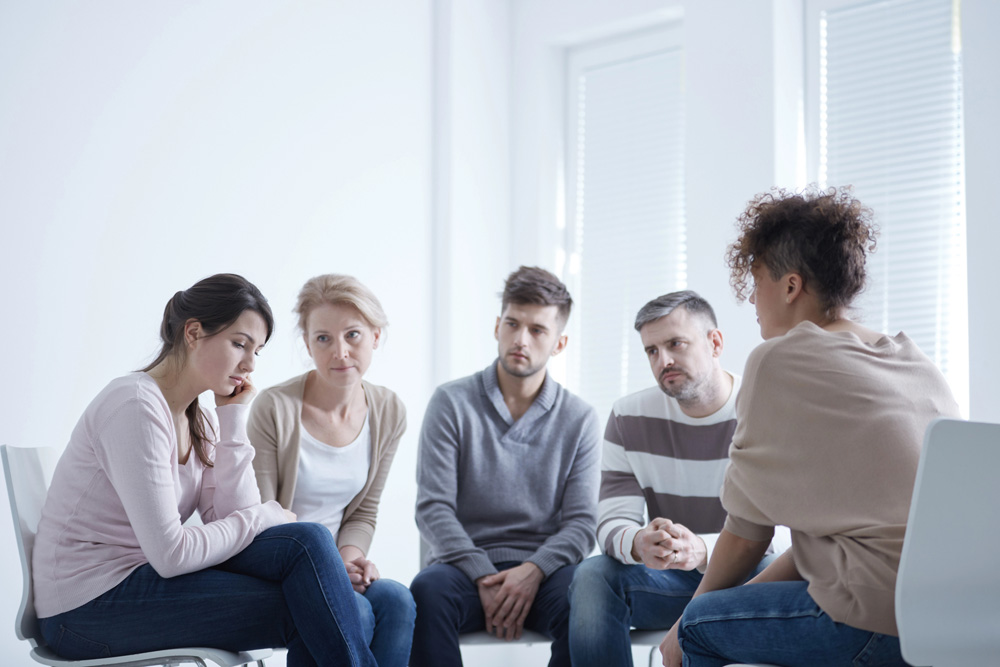 Group supporting sad woman